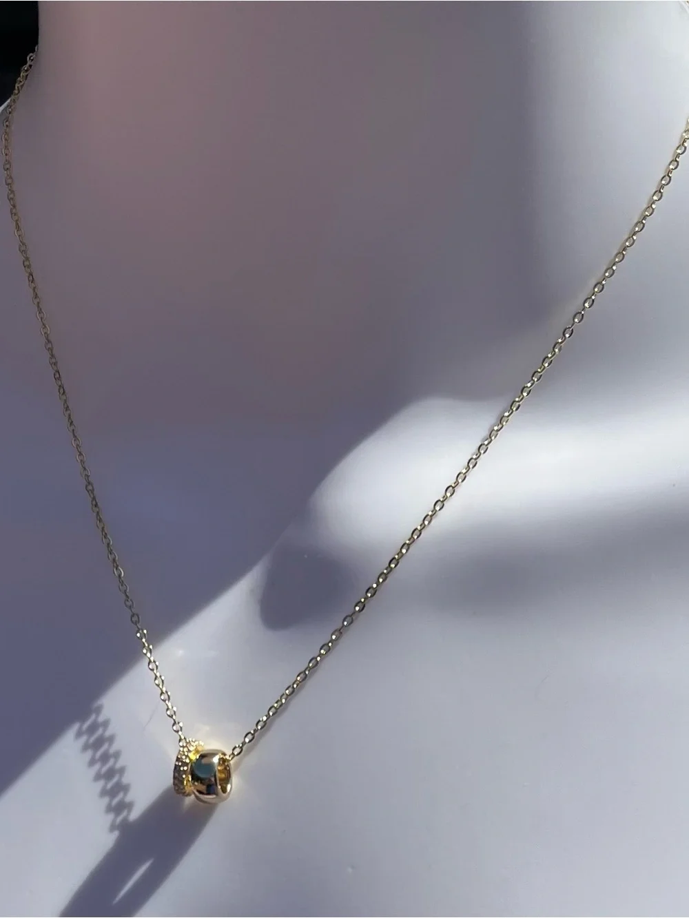Elegant gold-tone pendant necklace featuring a pavé double ring design. NWT.